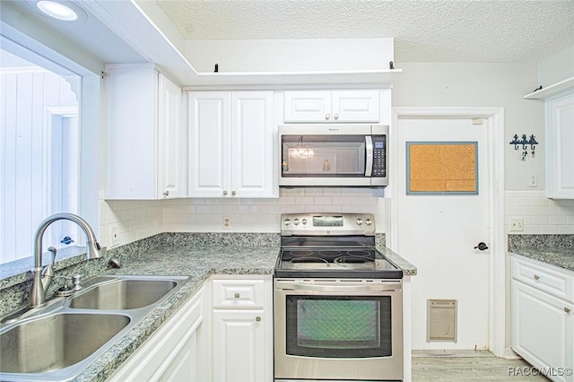 6176 W Pinedale Cir, Crystal River, FL 34429 - kitchen featuring appliances with stainless steel finishes, backsplash, white cabinetry, and a textured ceiling