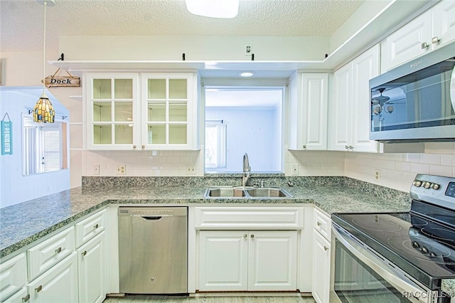 6176 W Pinedale Cir, Crystal River, FL 34429 - kitchen featuring stainless steel appliances, backsplash, glass insert cabinets, white cabinetry, and a textured ceiling