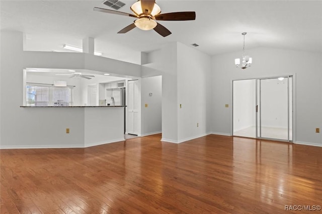 unfurnished living room featuring vaulted ceiling, ceiling fan with notable chandelier, and hardwood / wood-style floors