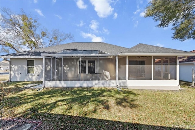 rear view of property with a sunroom and a lawn