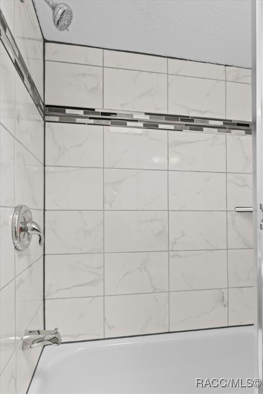 bathroom featuring tiled shower / bath