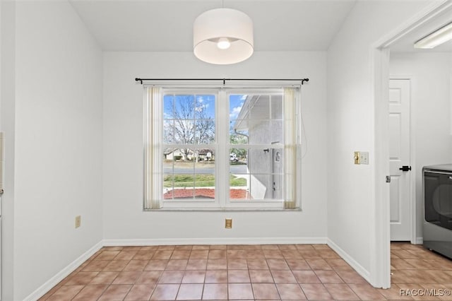 spare room with washer / clothes dryer and light tile patterned floors