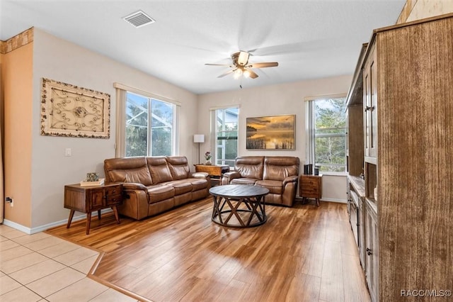 living area with light wood-type flooring, visible vents, and a healthy amount of sunlight