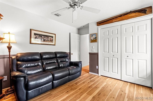 living room featuring visible vents, ceiling fan, and light wood finished floors