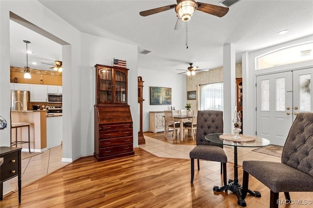 living area with baseboards, visible vents, and light wood finished floors