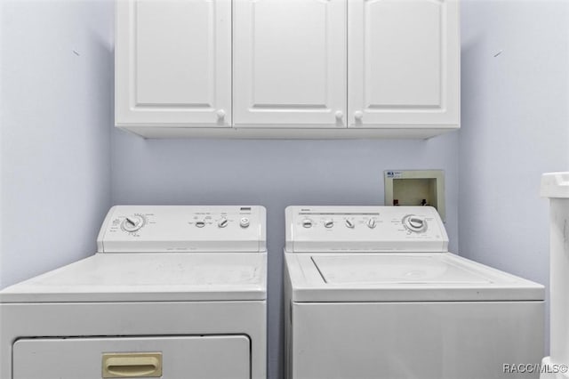 laundry room with separate washer and dryer and cabinet space