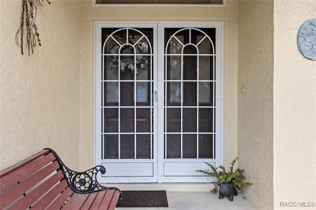 entrance to property with stucco siding