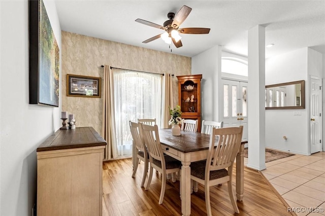 dining space with a ceiling fan, light wood-style flooring, and baseboards