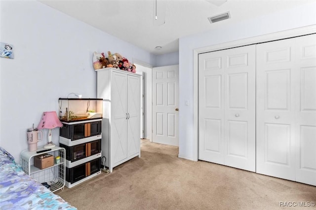 bedroom featuring light colored carpet, a closet, and visible vents