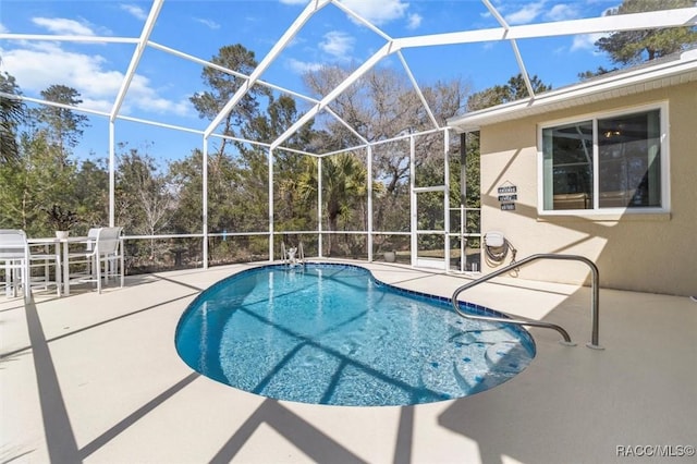 pool featuring glass enclosure and a patio area