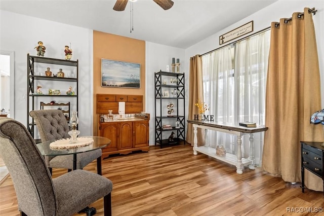 living area featuring light wood-style flooring and ceiling fan