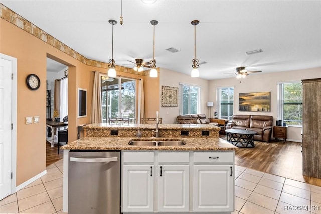 kitchen with white cabinets, dishwasher, open floor plan, pendant lighting, and a sink