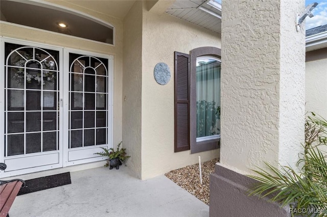 property entrance with french doors and stucco siding