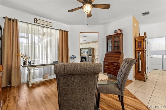 dining area with light wood-type flooring, visible vents, ceiling fan, and separate washer and dryer