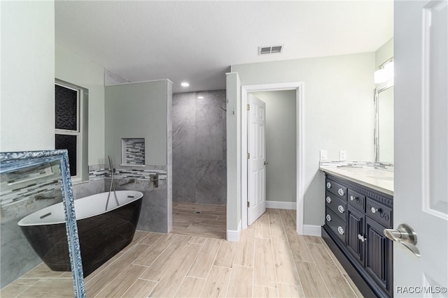 19028 SW 101st Pl, Dunnellon, FL 34432 - full bath featuring walk in shower, vanity, a soaking tub, wood finish floors, and baseboards