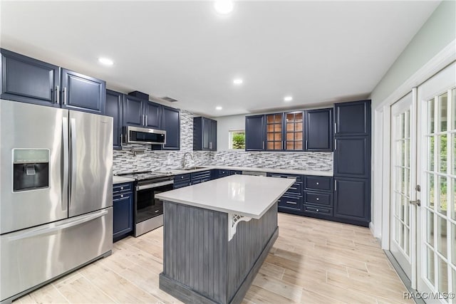19028 SW 101st Pl, Dunnellon, FL 34432 - kitchen with stainless steel appliances, blue cabinets, decorative backsplash, light countertops, and glass insert cabinets