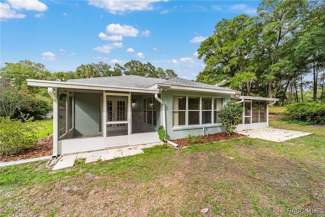 19028 SW 101st Pl, Dunnellon, FL 34432 - back of property featuring a sunroom, french doors, a lawn, and roof with shingles