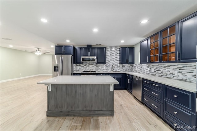 19028 SW 101st Pl, Dunnellon, FL 34432 - kitchen with appliances with stainless steel finishes, light countertops, tasteful backsplash, a kitchen island, and recessed lighting
