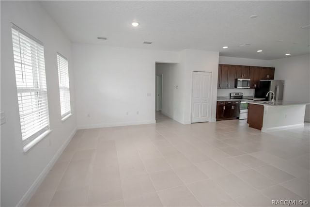 unfurnished living room with a healthy amount of sunlight and light tile patterned flooring