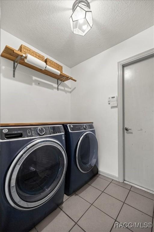 4357 N Indianhead Rd, Hernando, FL 34442 - laundry area featuring washer and dryer, light tile patterned floors, and a textured ceiling