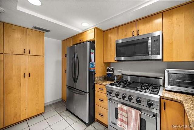 4357 N Indianhead Rd, Hernando, FL 34442 - kitchen featuring appliances with stainless steel finishes, light tile patterned floors, light stone counters, a textured ceiling, and recessed lighting