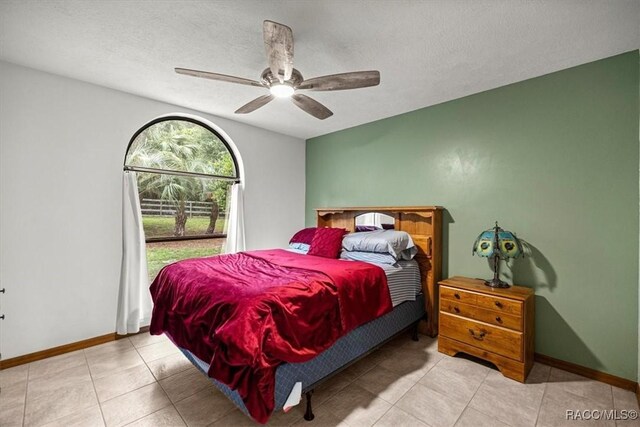 4357 N Indianhead Rd, Hernando, FL 34442 - tiled bedroom with baseboards, a ceiling fan, and a textured ceiling