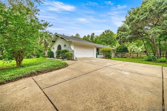 4357 N Indianhead Rd, Hernando, FL 34442 - view of property exterior with driveway, fence, stucco siding, and an attached garage