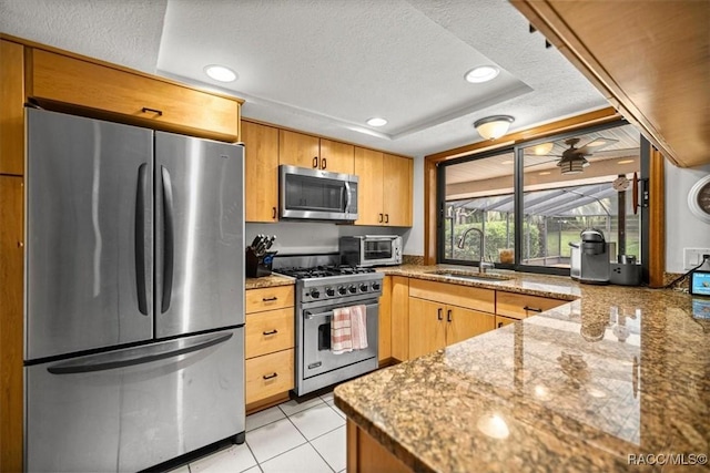 4357 N Indianhead Rd, Hernando, FL 34442 - kitchen with appliances with stainless steel finishes, a sink, a tray ceiling, stone countertops, and light tile patterned floors