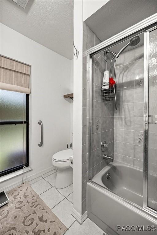 4357 N Indianhead Rd, Hernando, FL 34442 - bathroom featuring tile patterned flooring, bath / shower combo with glass door, toilet, and baseboards
