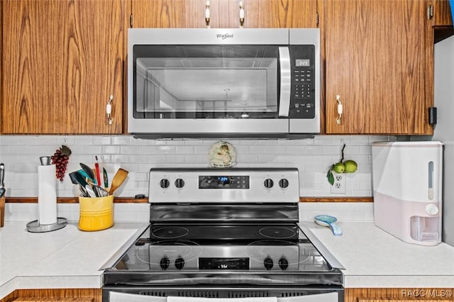 kitchen with appliances with stainless steel finishes and tasteful backsplash