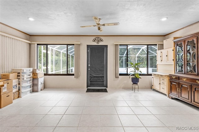 tiled entryway featuring a wealth of natural light and crown molding