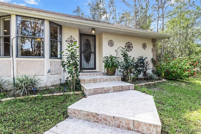 entrance to property featuring a yard