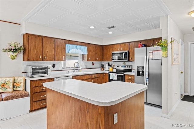 kitchen with appliances with stainless steel finishes, light tile patterned floors, a kitchen island, and sink