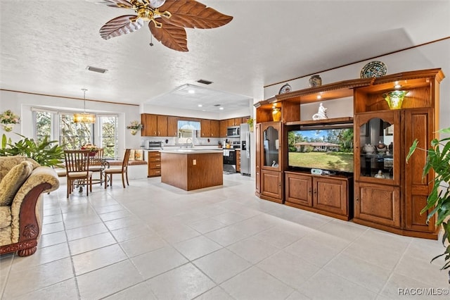 kitchen with decorative light fixtures, light tile patterned floors, a textured ceiling, and appliances with stainless steel finishes