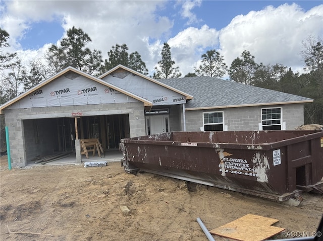 property under construction featuring concrete block siding, a garage, and a shingled roof