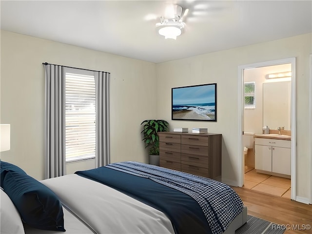 8599 N Messina Loop, Crystal River, FL 34428 - bedroom with light wood-style flooring, ensuite bath, and a sink