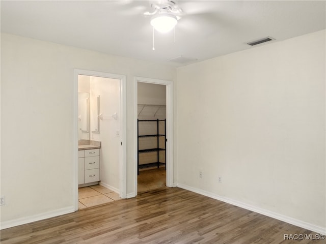 8599 N Messina Loop, Crystal River, FL 34428 - unfurnished bedroom featuring light wood-style floors, a spacious closet, a closet, and baseboards