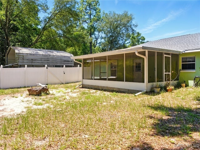 8599 N Messina Loop, Crystal River, FL 34428 - rear view of property featuring a sunroom, a gate, a fenced backyard, and roof with shingles