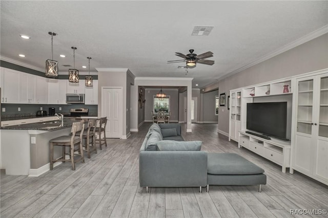 living room with ceiling fan, sink, crown molding, and light hardwood / wood-style floors