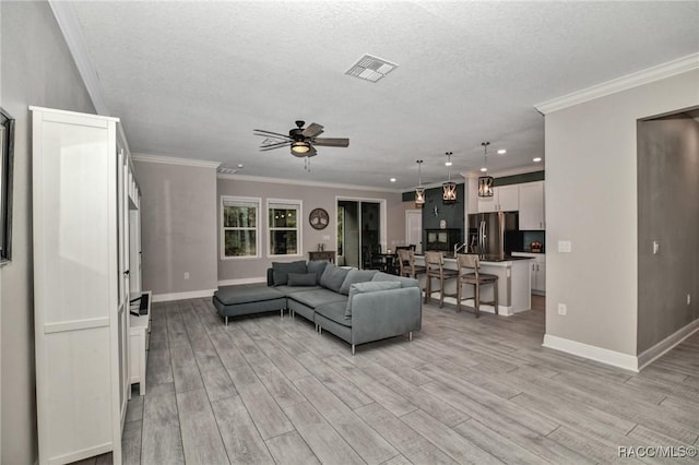 living room featuring ceiling fan, ornamental molding, and light hardwood / wood-style floors