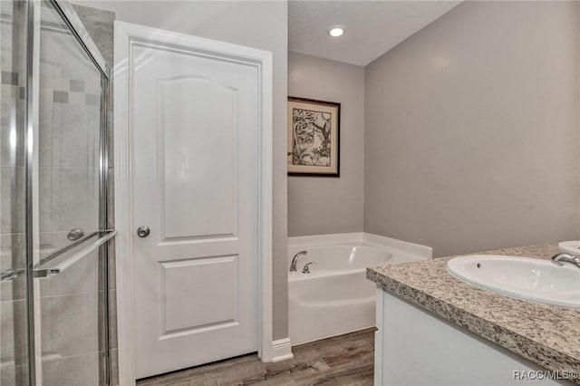 bathroom featuring independent shower and bath, vanity, and hardwood / wood-style floors