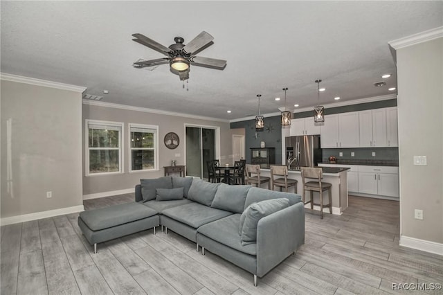 living room featuring ornamental molding and ceiling fan