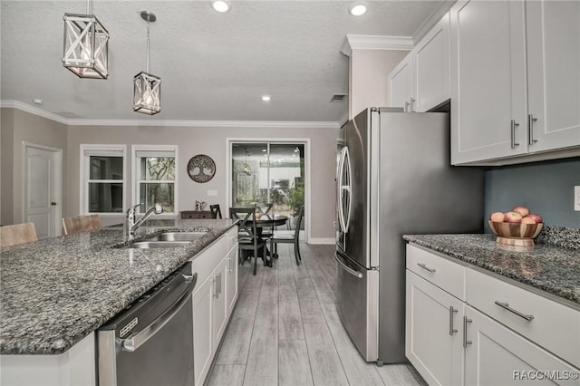 kitchen featuring stainless steel appliances, white cabinetry, sink, and dark stone counters