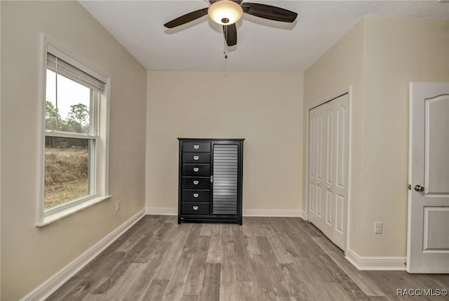 unfurnished bedroom featuring light hardwood / wood-style floors, ceiling fan, and a closet