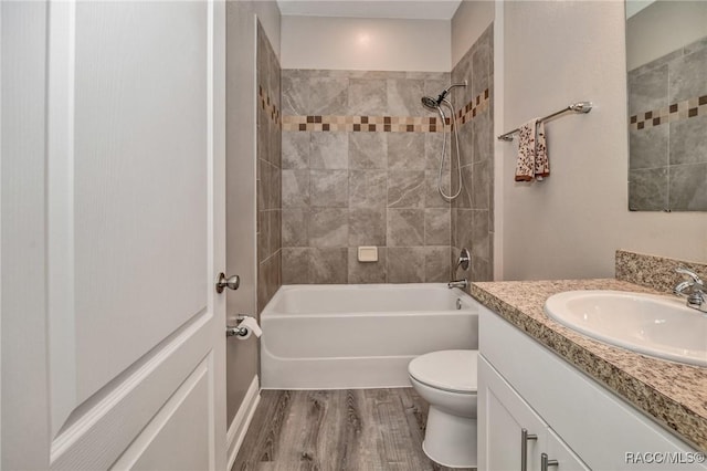 full bathroom featuring wood-type flooring, toilet, vanity, and tiled shower / bath