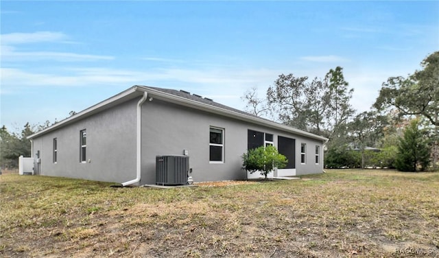 view of property exterior with central AC unit and a yard