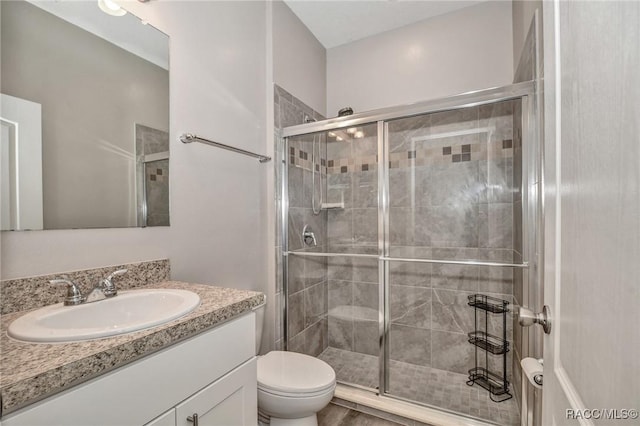 bathroom with vanity, toilet, and an enclosed shower