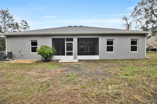 rear view of property featuring a sunroom, a lawn, and central air condition unit