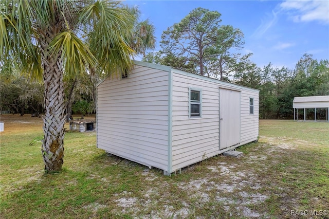 view of outbuilding featuring a carport and a lawn