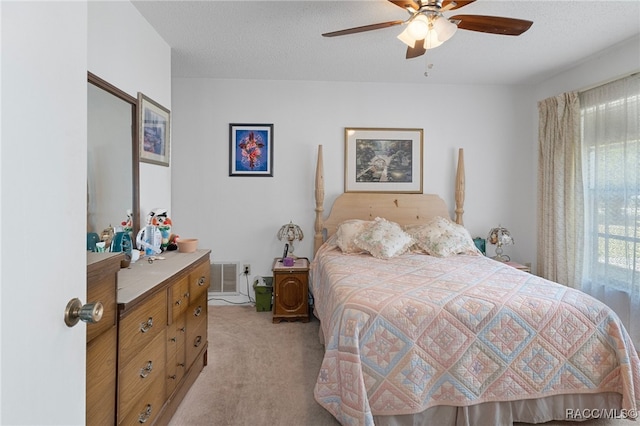 carpeted bedroom with a textured ceiling and ceiling fan